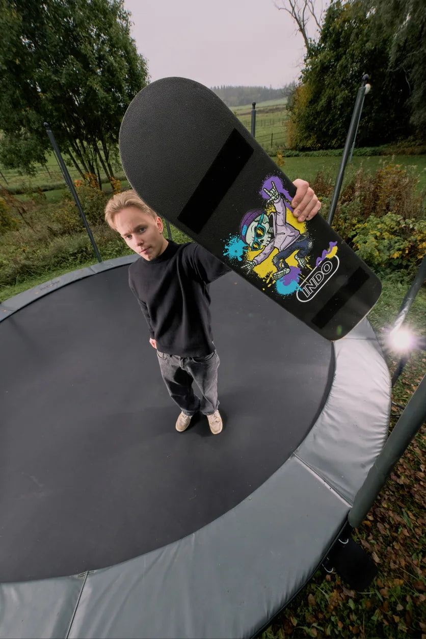 Rider holding the INDO Skate on a trampoline